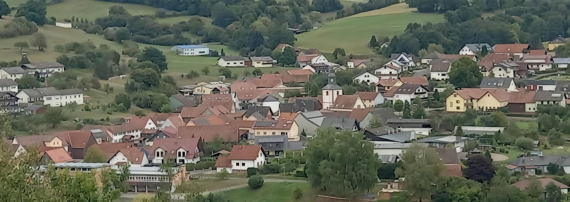 Blick über Weichersbach im Sinntal mit Hügeln und Wäldern